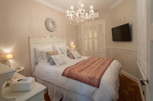 a bedroom with a white bed with a chandelier at Guesthouse Elisabeth Maastricht in Maastricht