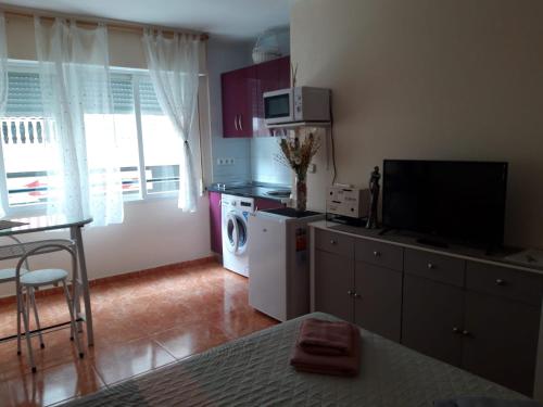 ein Wohnzimmer mit einer Küche mit einer Waschmaschine und einem Trockner in der Unterkunft Almudena Estudio in Torrevieja