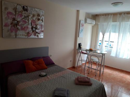 a bedroom with a bed and a table and a window at Almudena Estudio in Torrevieja