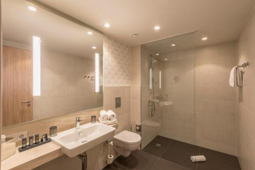 a bathroom with a sink and a toilet and a shower at Holiday Inn - Hamburg - Berliner Tor by IHG in Hamburg