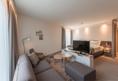 a hotel room with a couch and a bed at Holiday Inn - Hamburg - Berliner Tor by IHG in Hamburg
