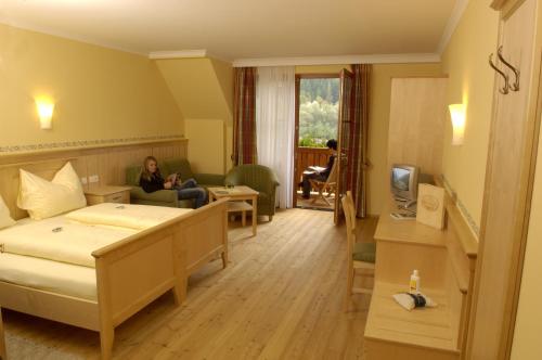 ein Hotelzimmer mit einer Frau auf einem Bett in der Unterkunft Gasthof Hofbauer in Breitenau am Hochlantsch