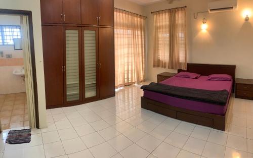 - une chambre avec un lit violet dans l'établissement Awani Homestay, à Permatang Janggus