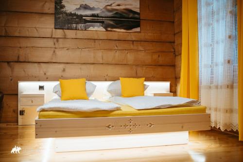 a bedroom with a bed with yellow pillows at Schronisko Stary Młyn in Zakopane