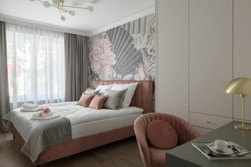 a bedroom with a bed and a chair and a desk at Flav Apartment in Kraków