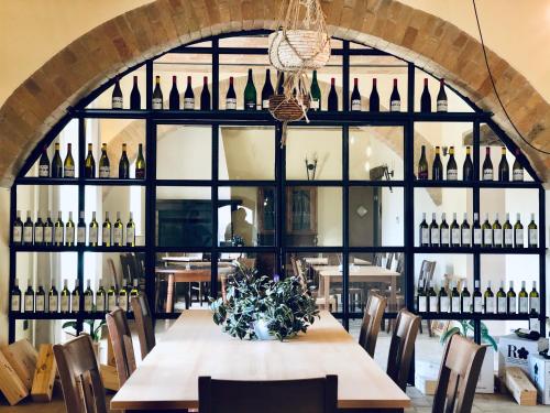a dining room with a table and a bunch of wine bottles at Casale Viridi - nel fresco delle colline Umbre in Narni