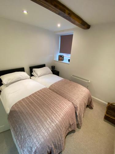 1 dormitorio con 2 camas y ventana en Buckingham House Apartment 2, en Macclesfield