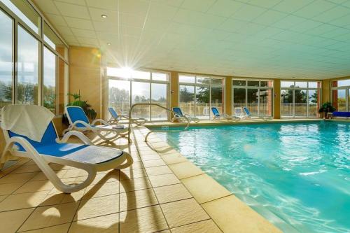 une grande piscine avec des chaises dans l'établissement Eagle, à Fréhel