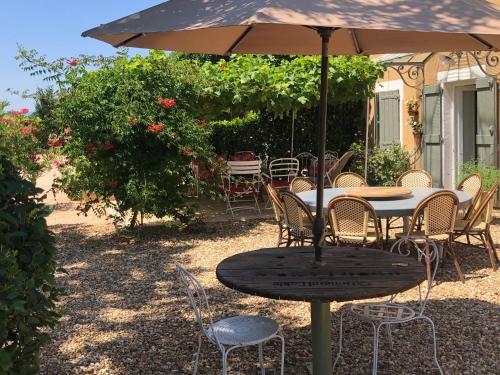 a table and chairs under an umbrella in a yard at La Gatille in Villié-Morgon