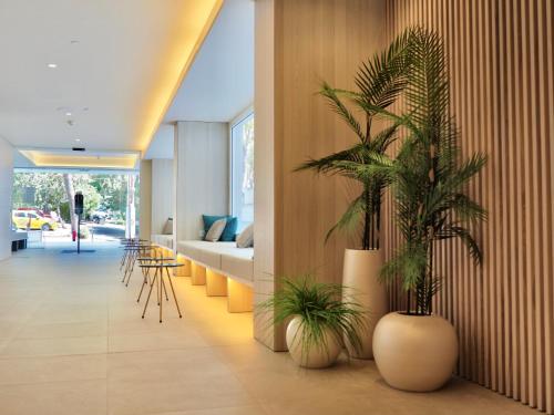 a living room with two potted plants on the wall at BQ Belvedere Hotel in Palma de Mallorca