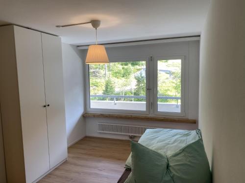 um quarto com uma janela, um sofá e um candeeiro em Gauenpark AL77 Wohnung Hutter em Flumserberg