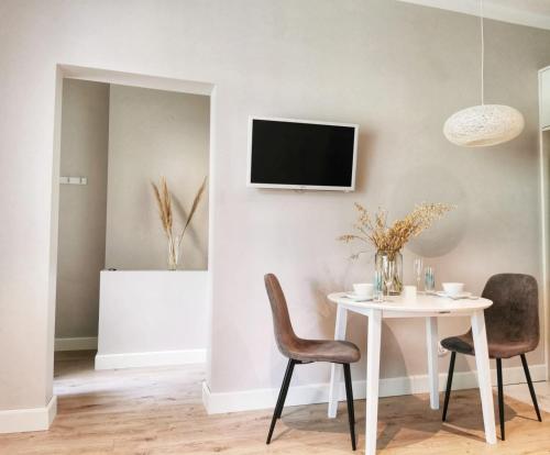 a dining room with a white table and chairs at Tolstoi Scandinavian 1 bedroom apartment + free parking in Tartu