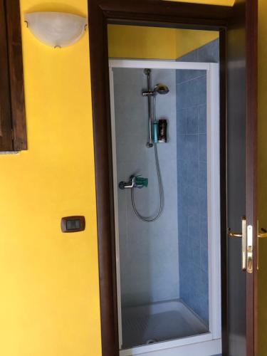 La salle de bains est pourvue d'une douche et d'une porte en verre. dans l'établissement Basicò un balcone sul mare - Casa SALITA FOTI -Case vacanza Sicilia&Toscana-, à Basicò
