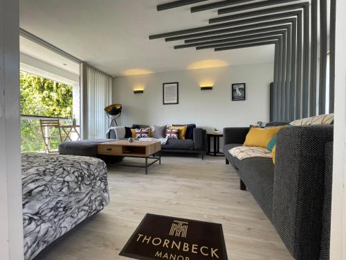 a living room with a couch and a table at Thornbeck Manor Lake Windermere in Windermere