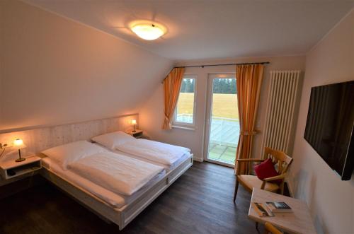 a bedroom with a bed and a large window at Berggasthof zur Glocke in Winterberg