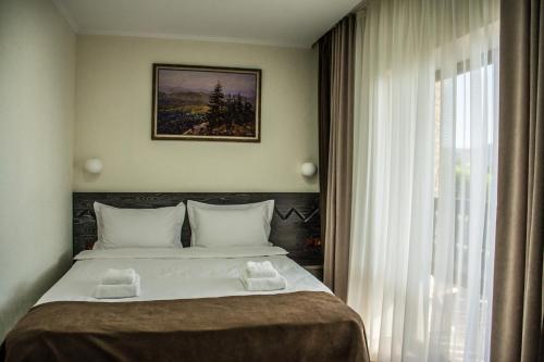 a bedroom with a large bed and a window at Синевирський Перевал in Synevyr