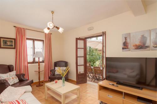 a living room with a large television and a couch at La Casa de Mamasita in Queveda