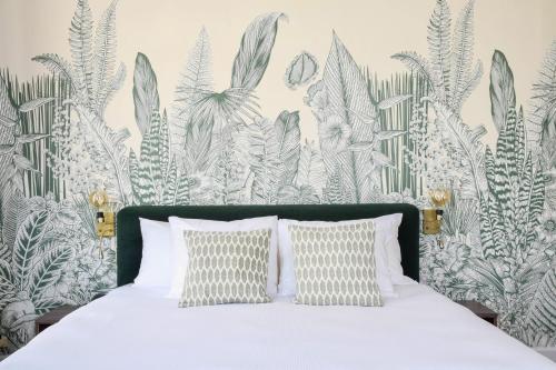 een slaapkamer met een bed met tropisch behang bij Hotel Sebel in Den Haag