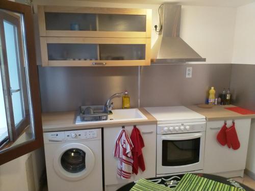 une cuisine avec une machine à laver et un évier dans l'établissement Petite maisonnette d'environ 25m2 tout confort, à Oraison