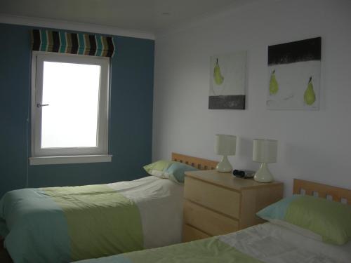 1 Schlafzimmer mit 2 Betten und einem Fenster in der Unterkunft Beach View Apartment in Ventnor