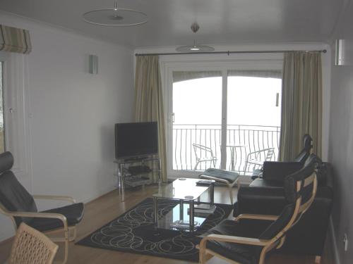 a living room with a couch and chairs and a table at Beach View Apartment in Ventnor
