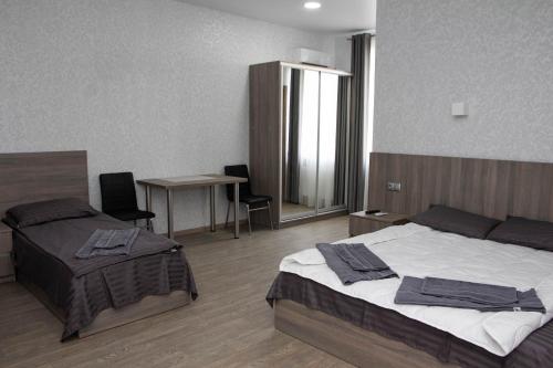 a hotel room with two beds and a table and chairs at Hotel Voyage Вояж in Umanʼ