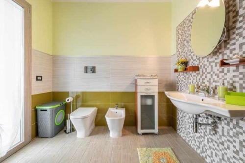 a bathroom with a sink and a toilet and a mirror at Larcobaleno di Chia in Domus de Maria