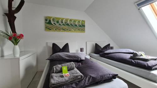 two beds in a room with purple pillows at stay!apart Gieckau in Naumburg