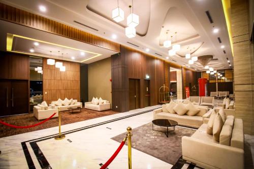 a lobby with white couches and a red rope at Asialink Hotel Batam by Prasanthi in Nagoya