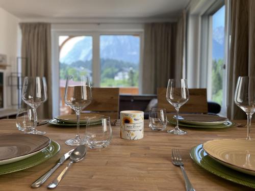a wooden table with wine glasses and plates on it at Panorama Lodge Mountainview 208 in Tauplitz