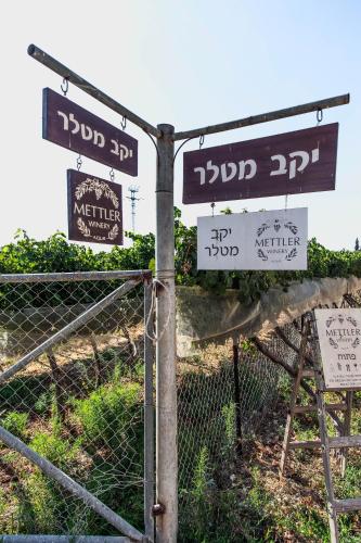 a pole with street signs on it next to a fence at Mettler Winery in ‘Ajjūr
