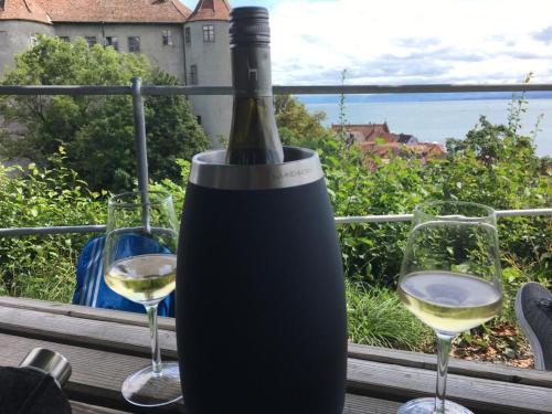 a bottle of wine sitting on a table with two glasses at Ferienwohnungen Bohner/ Wohnung Katharina in Meersburg