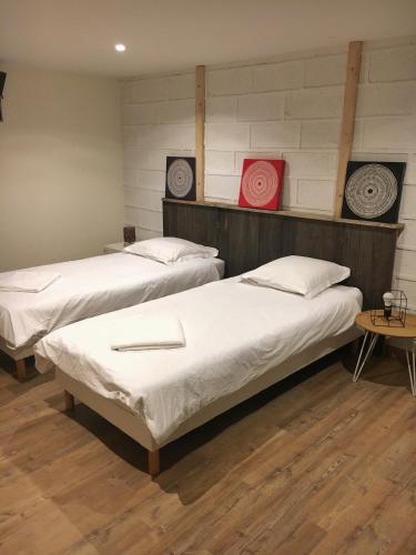 - une chambre avec 2 lits et une horloge rouge dans l'établissement Apt calme VUE LAC - 2 Chambres - Sauna, à Annecy