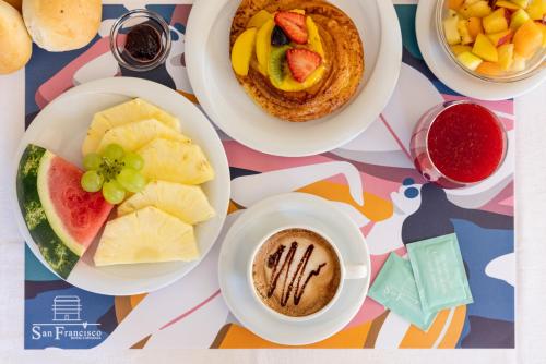une table garnie d'assiettes de nourriture et d'une tasse de café dans l'établissement Hotel San Francisco, à Lido di Savio