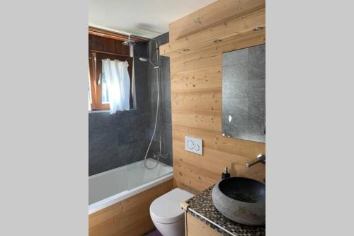 ein Badezimmer mit einem WC, einem Waschbecken und einer Badewanne in der Unterkunft Appartement familial cosy - 2 à 6 personnes in Crans-Montana