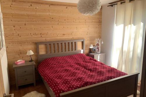 ein Schlafzimmer mit einem Bett mit einer roten Decke in der Unterkunft Appartement familial cosy - 2 à 6 personnes in Crans-Montana