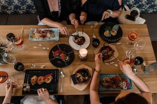 a group of people sitting around a table with food at Rossano Boutique Hotel & Ristorante in Ansbach