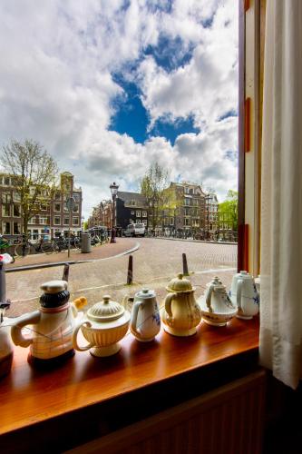 a row of tea pots sitting on a window sill at Amsterdam Wiechmann Hotel in Amsterdam