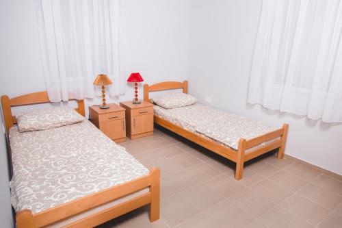 1 dormitorio con 2 camas y 2 mesitas de noche con lámparas en Guesthouse Djukanovic, en Virpazar