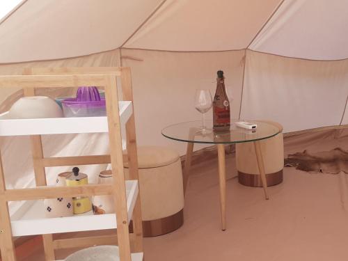 a tent with a table and a bottle of wine at Farm Glamping tent on Acquaviva Bay in Marittima