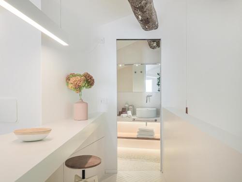a white bathroom with a mirror and a stool at Dreamers Sea View in Manarola
