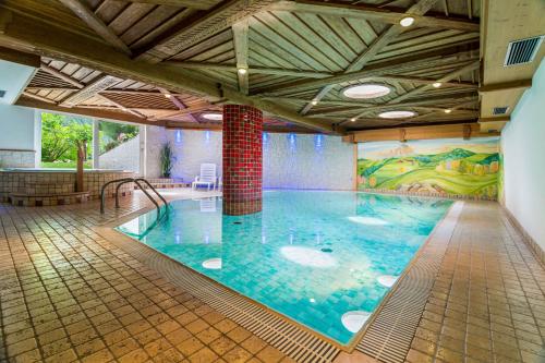 une grande piscine intérieure dans un bâtiment dans l'établissement Hotel Salvan, à Campitello di Fassa