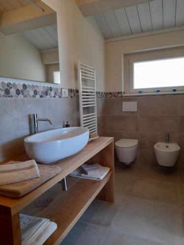 uma casa de banho com um lavatório e um WC em B&B Camera e Caffè em Osimo