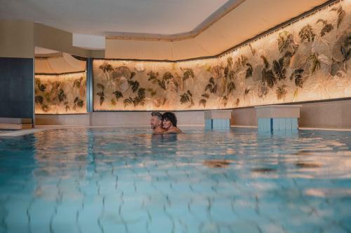 um homem está numa piscina em Garten-Hotel Ochensberger em Sankt Ruprecht an der Raab
