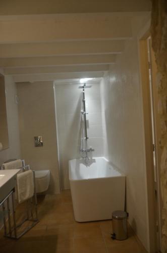 a bathroom with a bath tub and a sink at Le Murmure des Fées in Issigeac