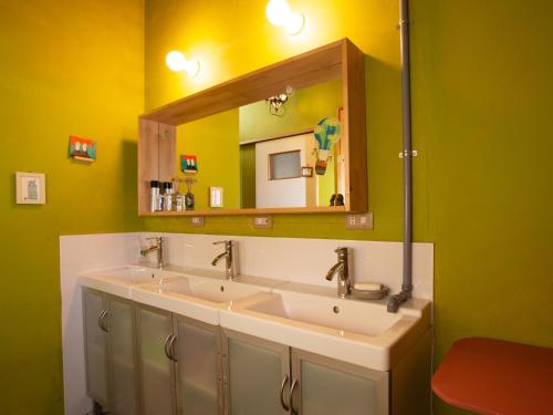a bathroom with two sinks and a mirror at Himeji 588 Guest House in Himeji