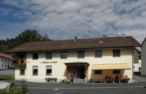 a large white building with a brown roof at Gasthof - Pension zur Post in Achslach