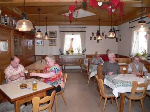 a group of people sitting at tables in a restaurant at Gasthof - Pension zur Post in Achslach