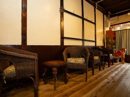 a row of chairs and tables in a room with wooden floors at Himeji 588 Guest House in Himeji