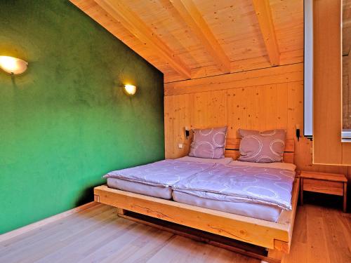 a bed in a room with a green wall at Ferienwohnung Schöpf in Kiefersfelden